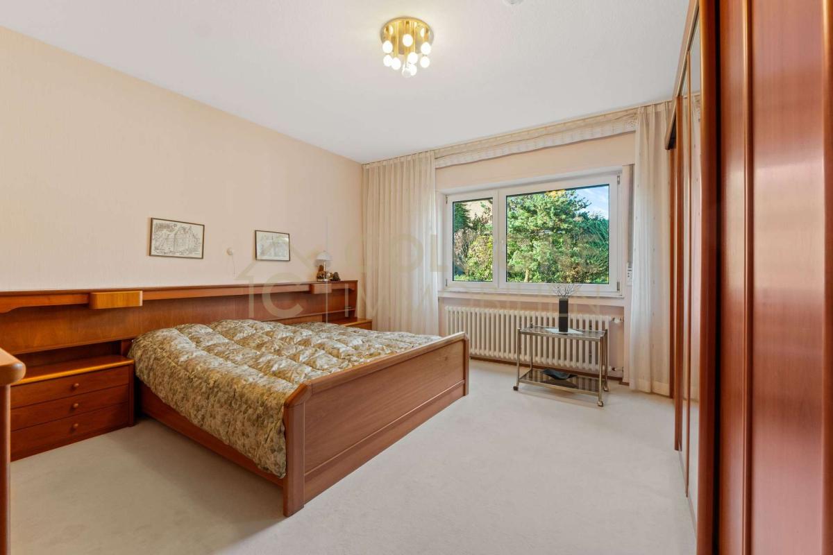 Geräumiges Elterschlafzimmer mit großen Fenstern in Richtung Garten